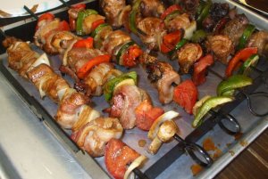 Кулинарный рецепт: Куриное мясо на шампурах с цуккини, шампиньонами и колбасками: Грилированный куриный шашлык с колбасными изделиями, цуккини, луком и шампиньонами, подается с томатным соусом
